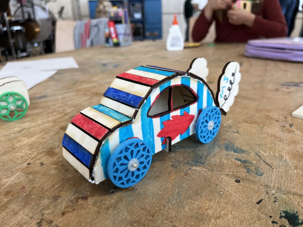 Ein Auto mit blauen und Roten STreifen und einem Auspuffdampf